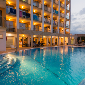 Schwimmbad des Bella Mar Hotels bei Nacht beleuchtet